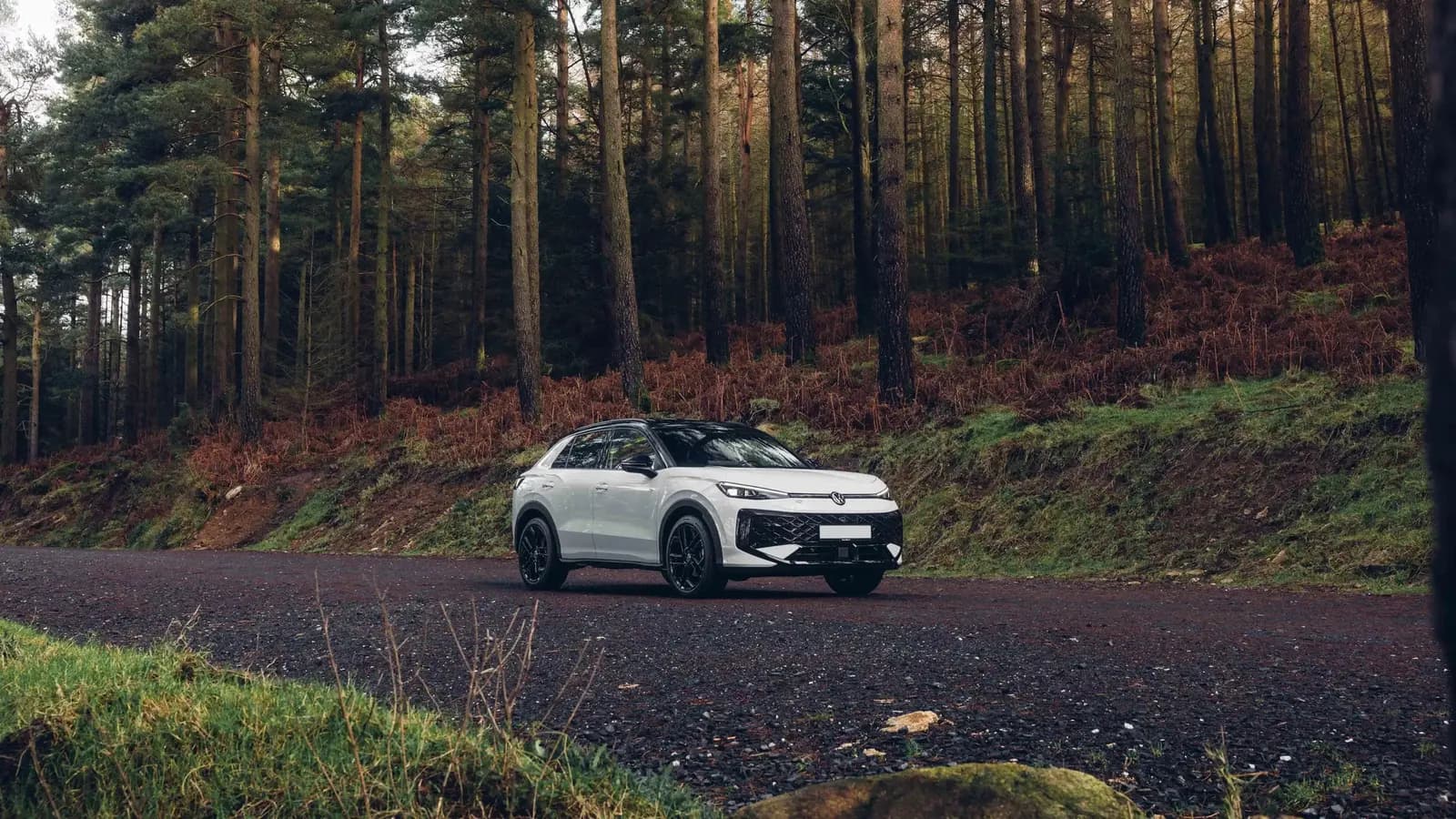 White all-new Volkswagen T-Roc on a forest road in Ireland